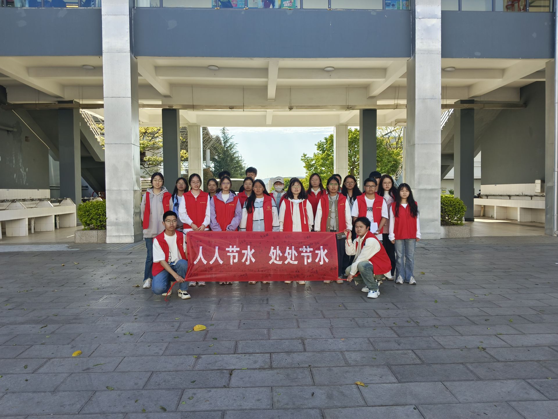 志愿者与签名横幅合影.jpg
